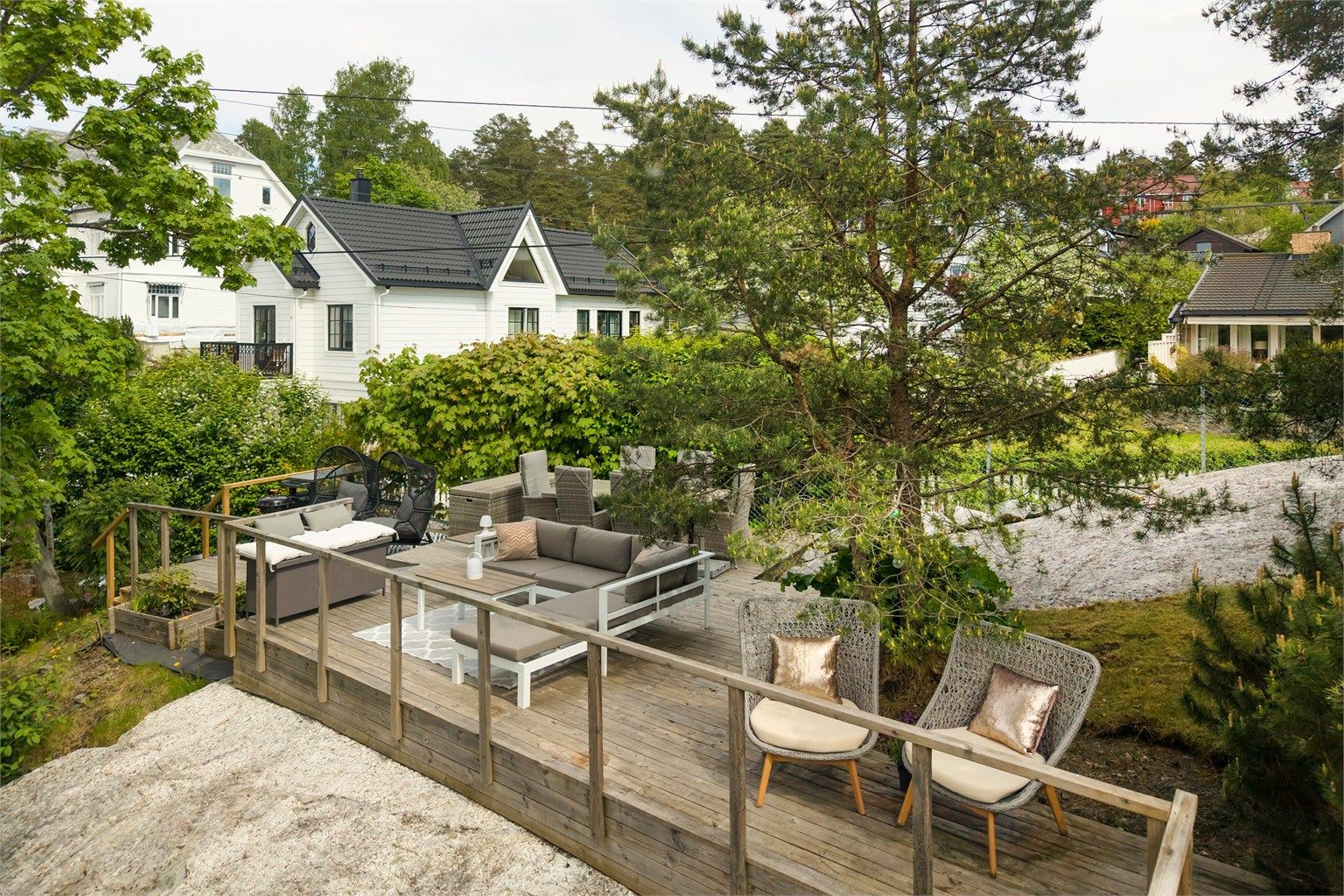 Den nedre delen av hagen har en stor platting med god plass til utemøbler.