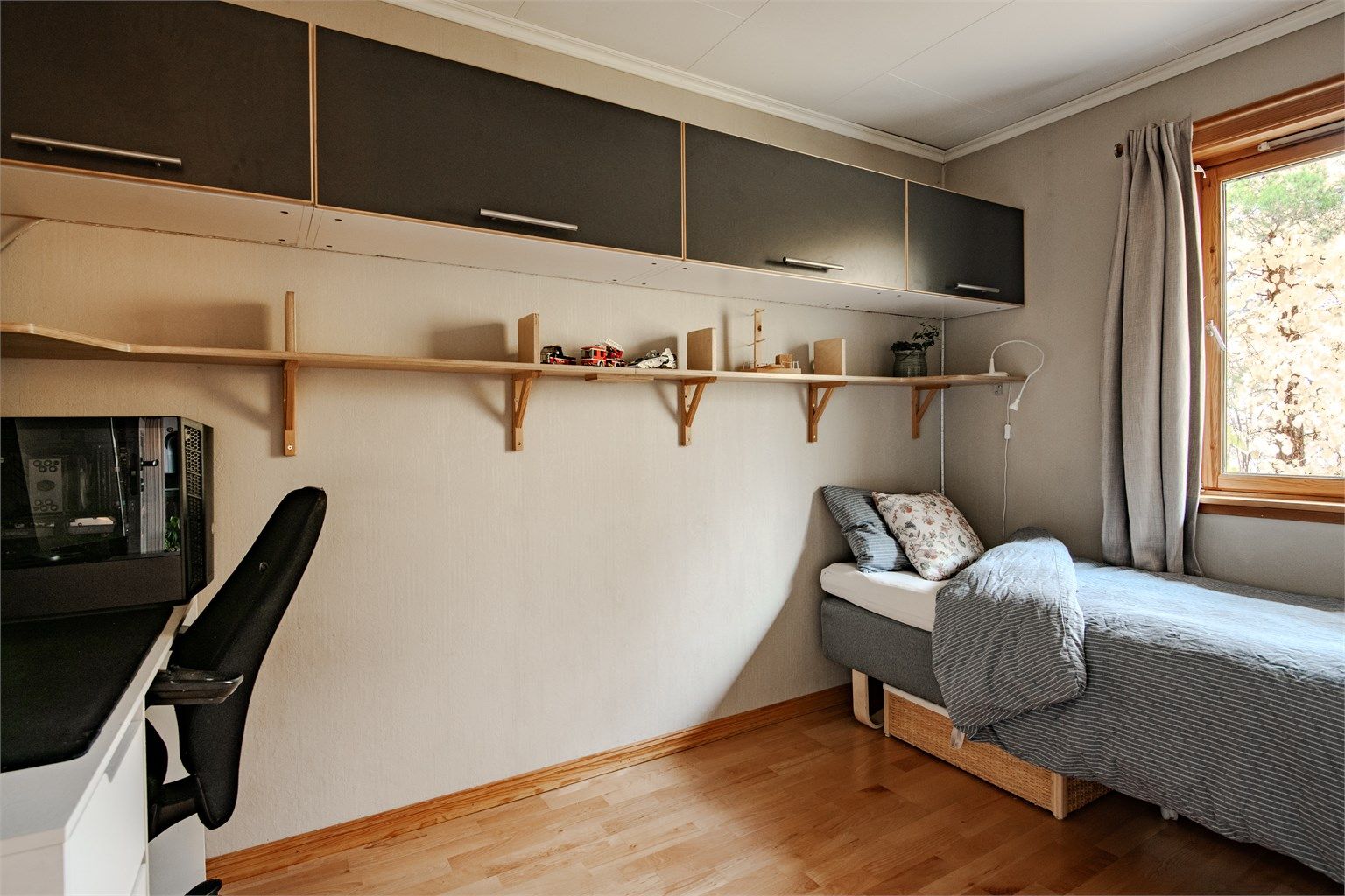 Soverom med vegghengte plassbesparende overskap og godt med rom til seng og arbeidsplass.