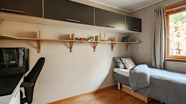 Soverom med vegghengte plassbesparende overskap og godt med rom til seng og arbeidsplass.