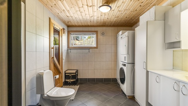 Bad/vaskerom i første etasje med gulvvarme og opplegg for vaskemaskin.