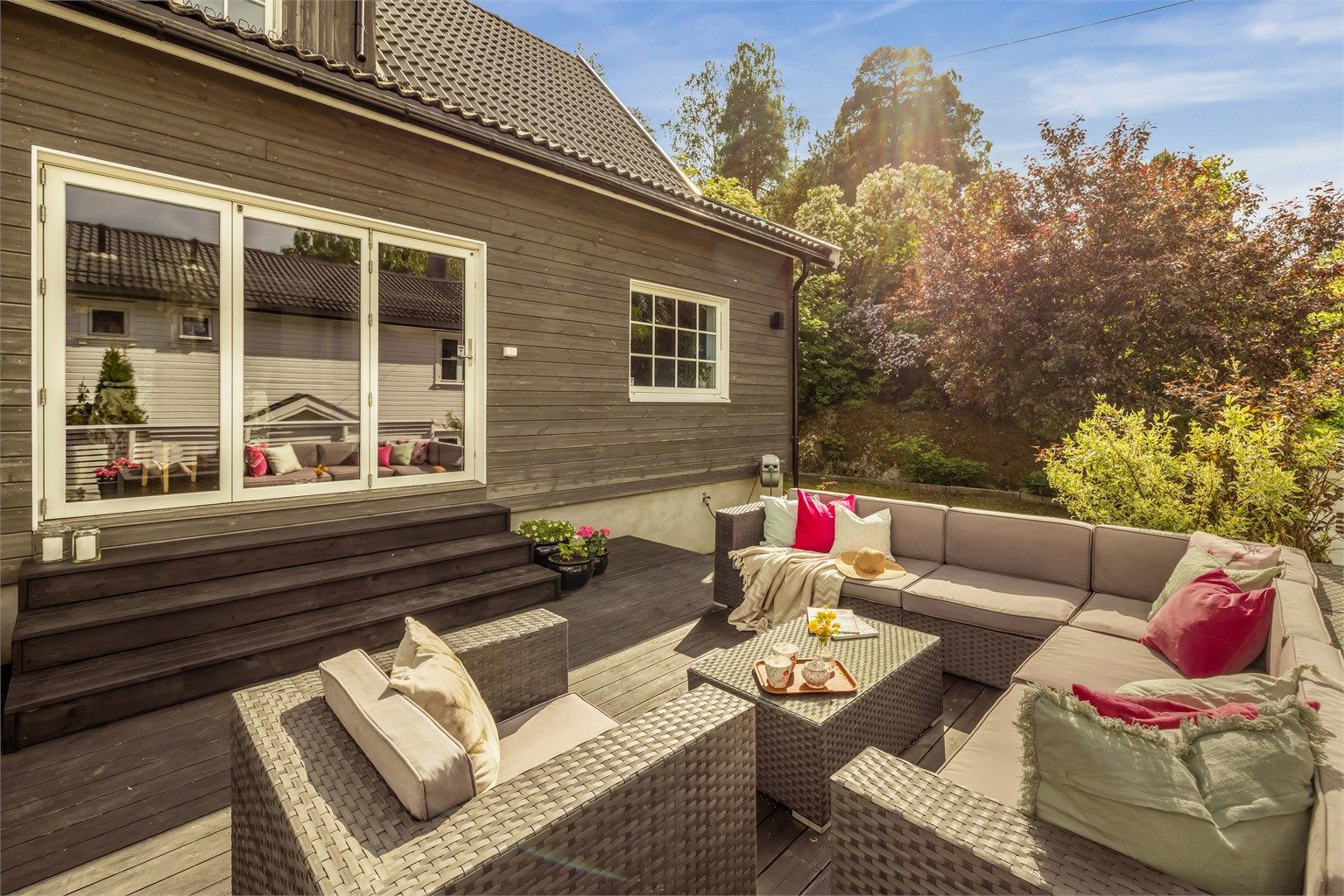Romslig terrasse på hele 39 kvm, belagt med terrassebord og med flott utsyn mot hagen. 