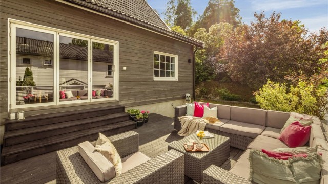 Romslig terrasse på hele 39 kvm, belagt med terrassebord og med flott utsyn mot hagen.