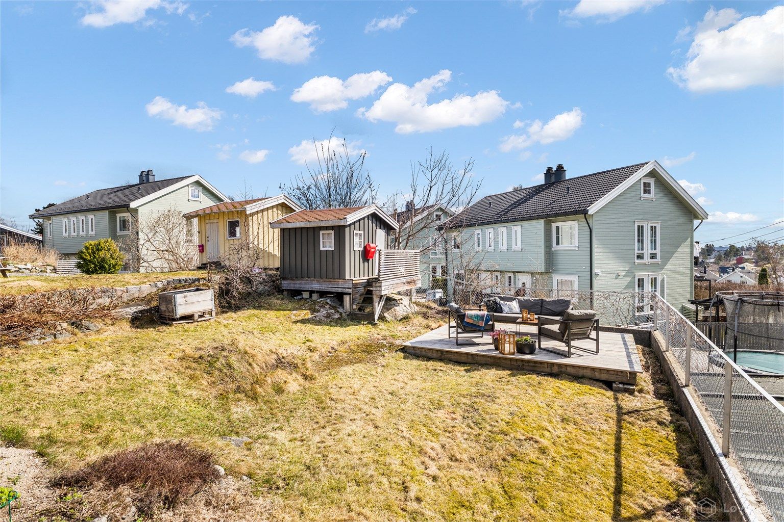 Hage med frittstående markterrasse og lekehus