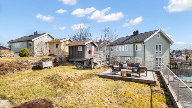 Hage med frittstående markterrasse og lekehus