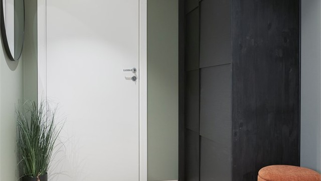 Man kommer inn i en romslig entré, med skyvedørsgarderobe for effektiv oppbevaring av yttertøy.