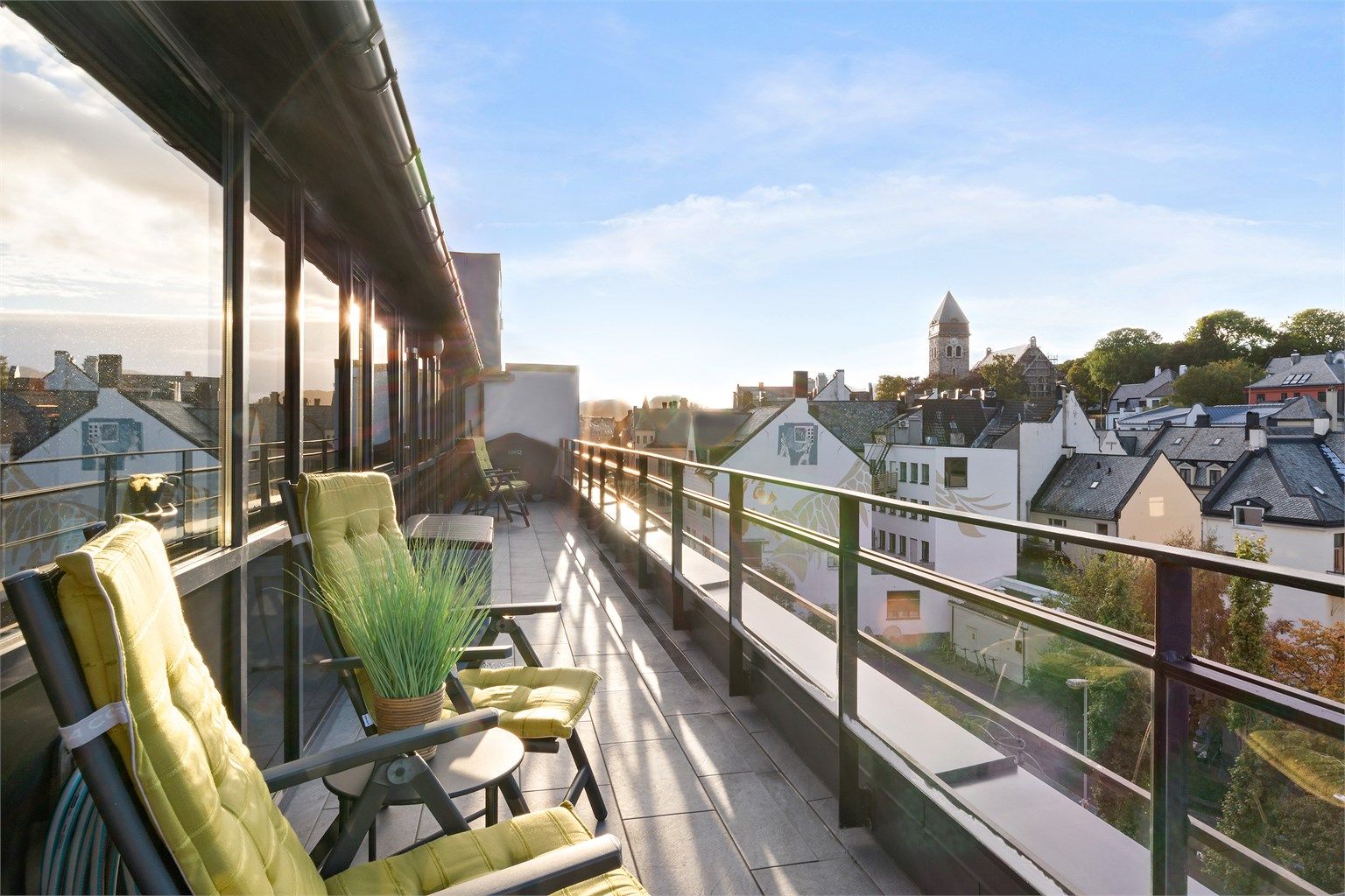 Terrassen med utgang fra kjøkken og soverom er på 23m² med rekkverk av glass og metall. Begge uteplassene har fått nytt flislagt dekke. Her er det og montert vannuttak