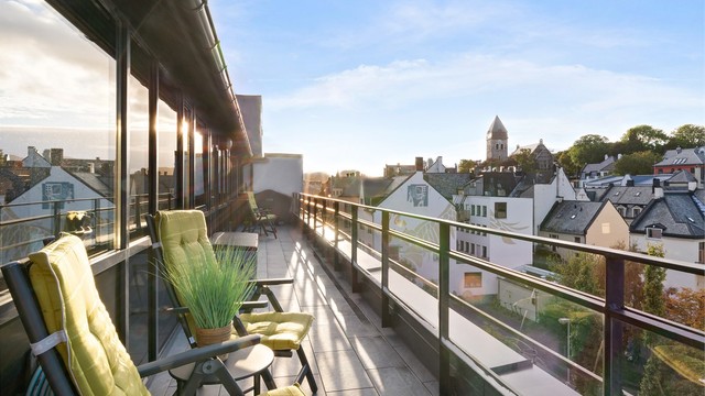 Terrassen med utgang fra kjøkken og soverom er på 23m² med rekkverk av glass og metall. Begge uteplassene har fått nytt flislagt dekke. Her er det og montert vannuttak