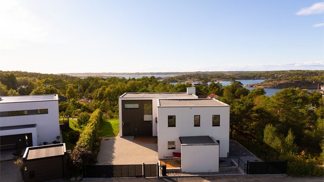 Port mot gaten er fjernstyrt. Hybelens innkjørsel sees til høyre, også denne med port.