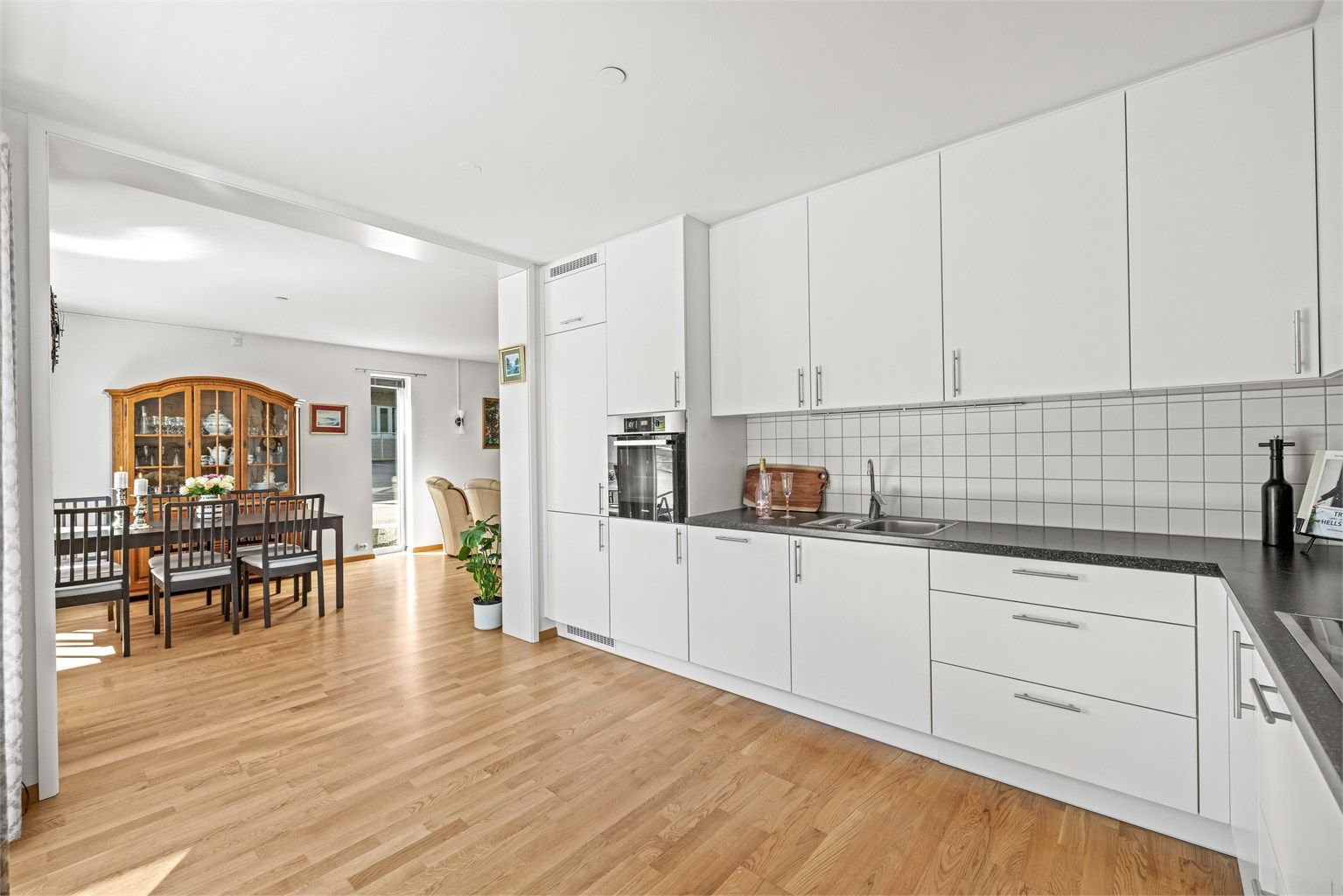 Den åpne løsningen mellom stue og kjøkken gir en sosial og luftig atmosfære.