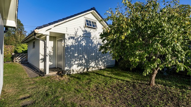 Garasjen har bakdør og loft med lagringsmuligheter.