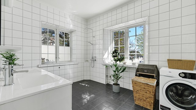 Rommet er kombinert bad og vaskerom, med opplegg for vaskemaskin.