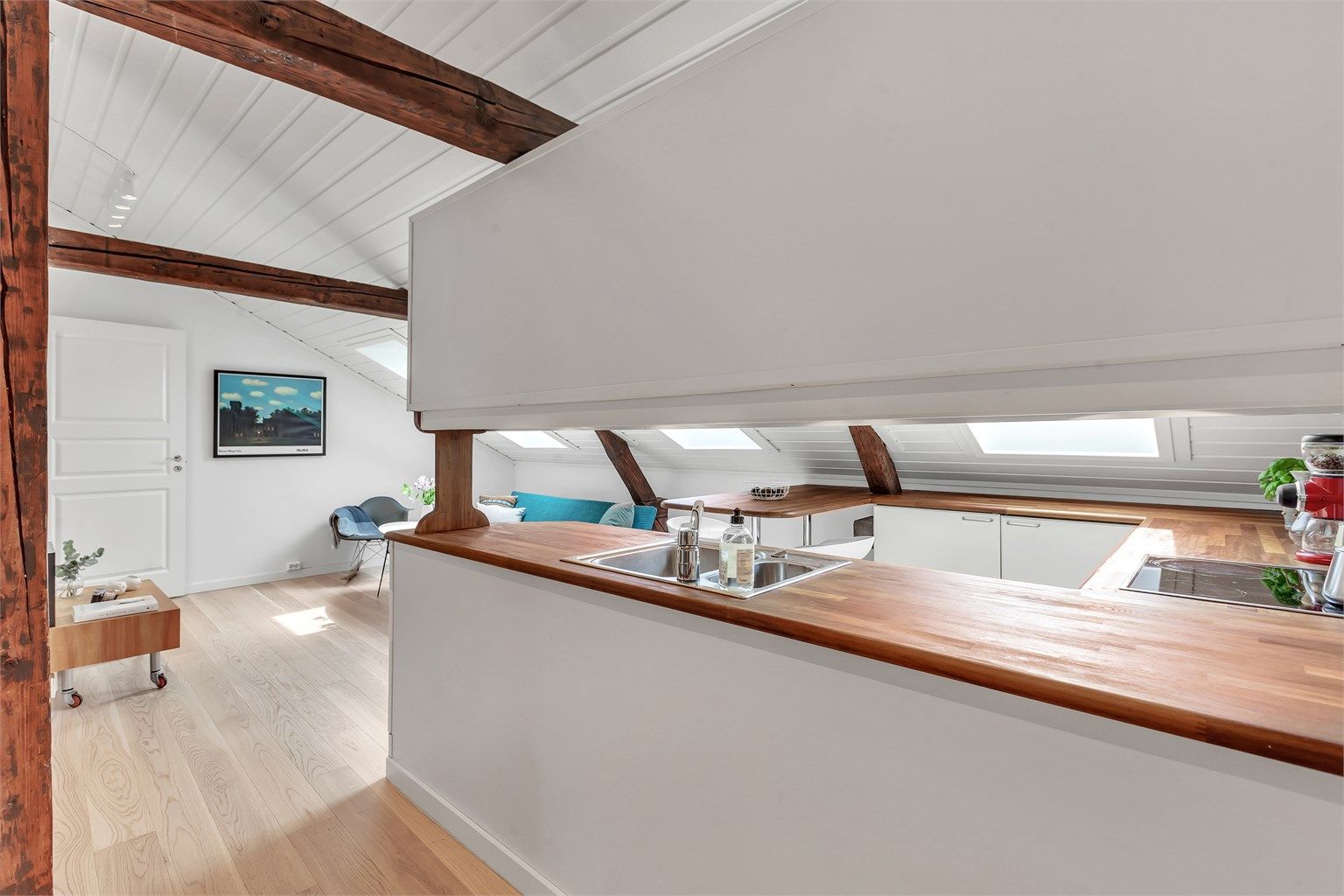 Stue og kjøkken i åpen løsning - tak og vegger i hele leiligheten er nymalt nå i juni.