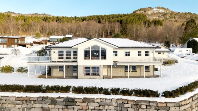 Eneboligen ligger på en romslig tomt på 1,6 mål med store, åpne plenarealer.