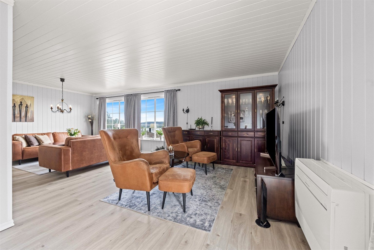Stuen er romslig og har plass til flere sittegrupper. En varmepumpe sørger for effektiv oppvarming.