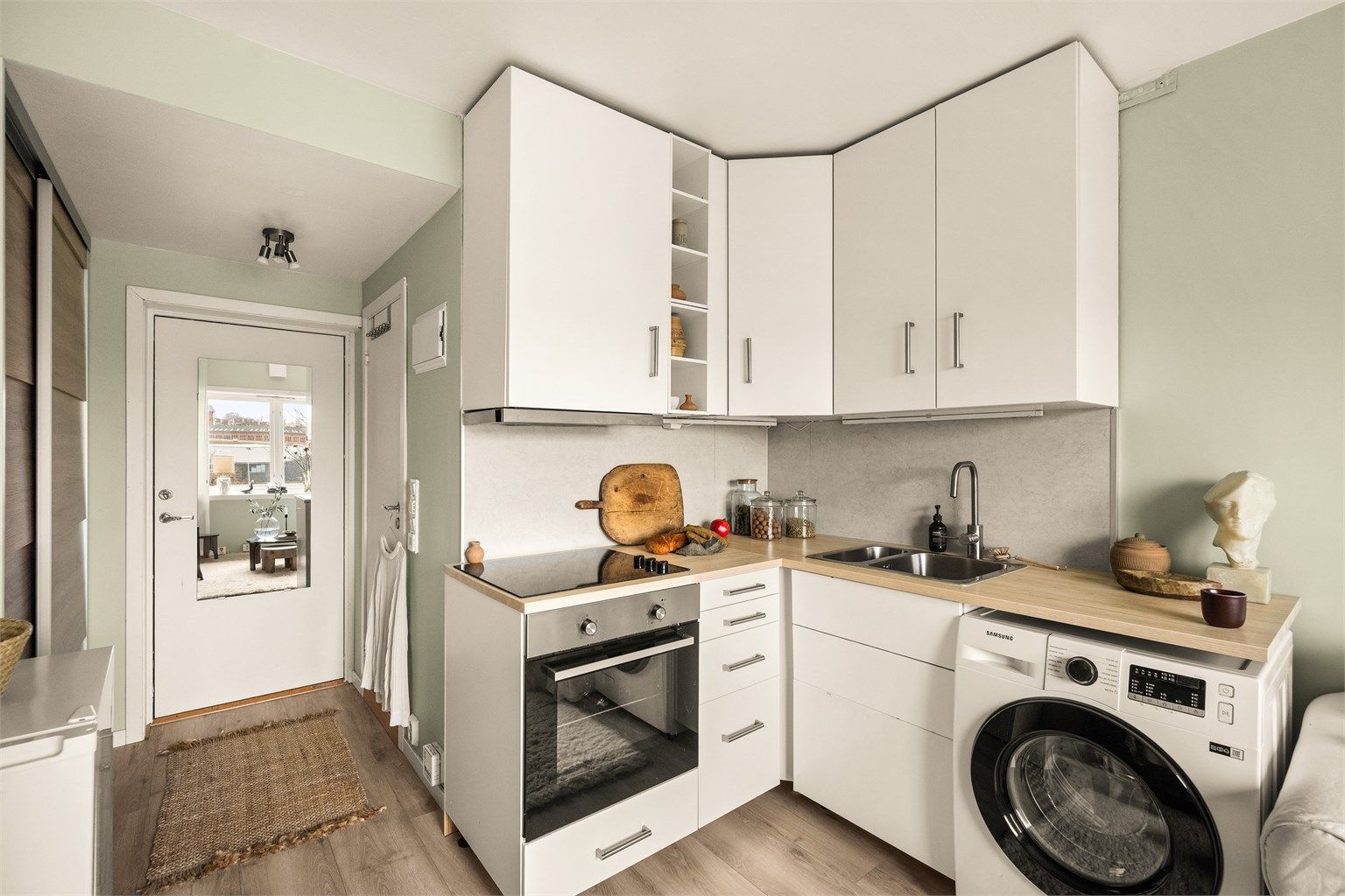 Pent kjøkken med smarte løsninger for oppbevaring og matlaging.