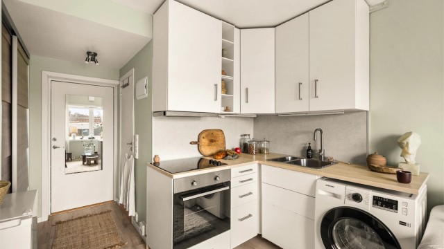 Pent kjøkken med smarte løsninger for oppbevaring og matlaging.