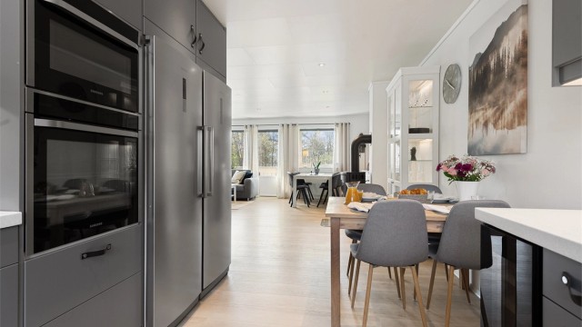 Fra kjøkkenet har du full oversikt over stuen, perfekt for å holde kontakten med gjester eller familie.