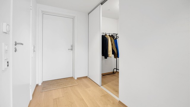 Gangen har plass til garderobeløsning og leder inn til leilighetens øvrige rom.