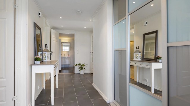 Innbydende entré med flislagt gulv med gulvvarme og downlights i himlingen.