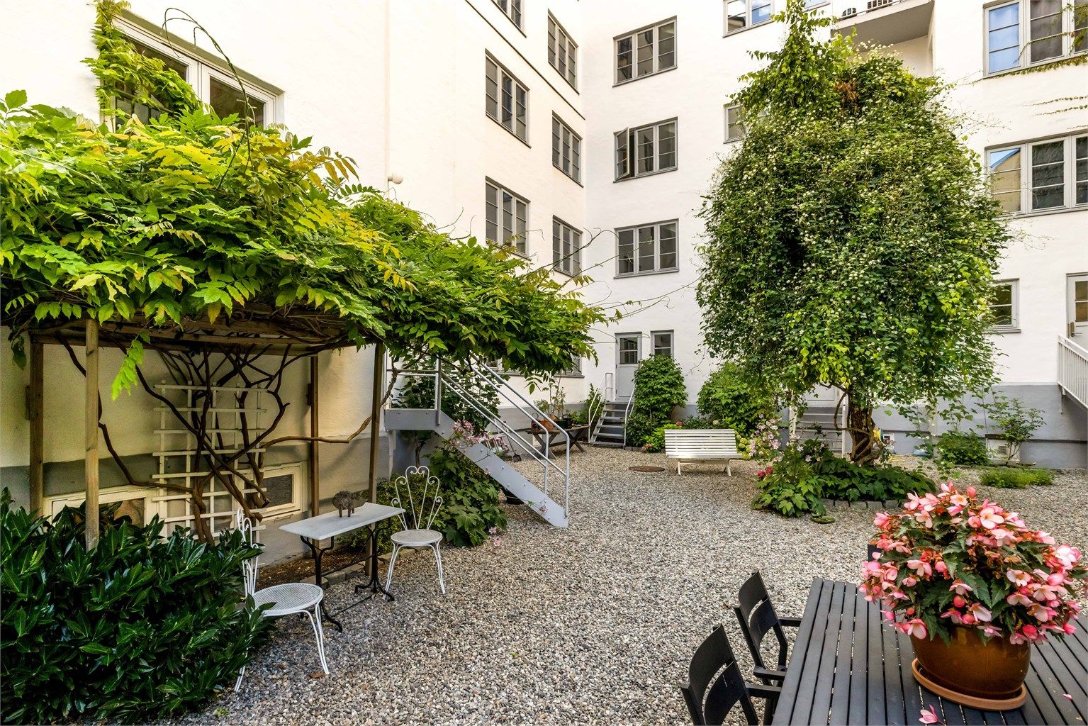 Bakgården er svært godt opparbeidet med gressplen, sittegrupper, trær og grill til felles bruk. 