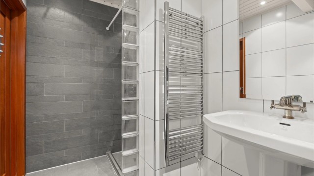Badet har vegghengt håndkletørker og et rør-i-rør-system for vannrørene.