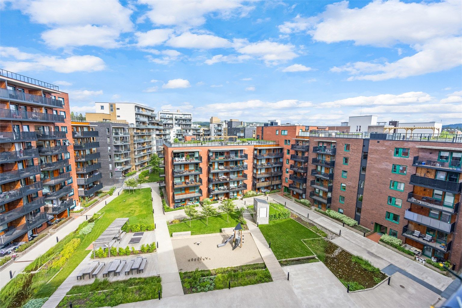 Fellesområdene er pent opparbeidet med plenarealer, lekeplass og beplantning.