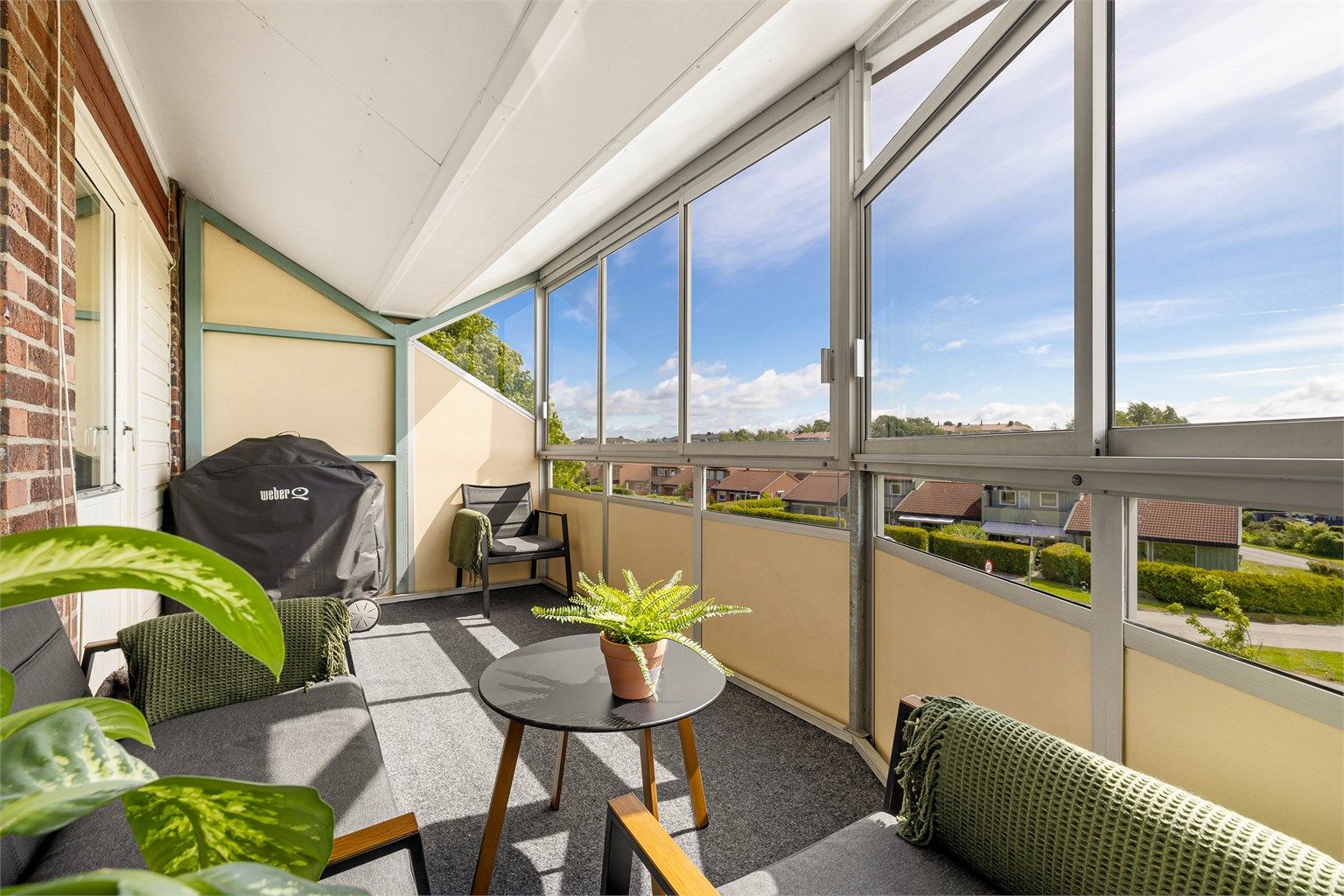 Skjermet av glass og overbygg er balkongen nærmest et ekstra rom. Flere av glassene kan trekkes til side for å gjøre balkongen mer luftig.