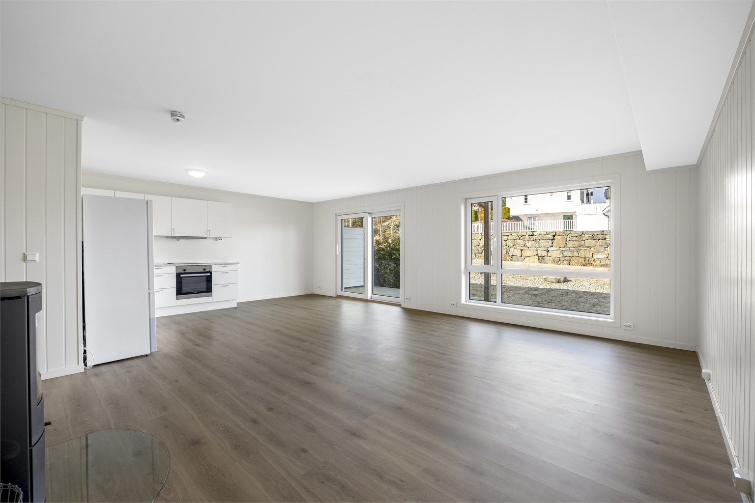 Det er en romslig stue med utgang til solrik uteplass