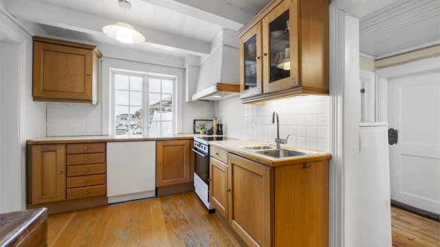 Kjøkkenet er utstyrt med integrert oppvaskmaskin og komfyr med avtrekksvifte.