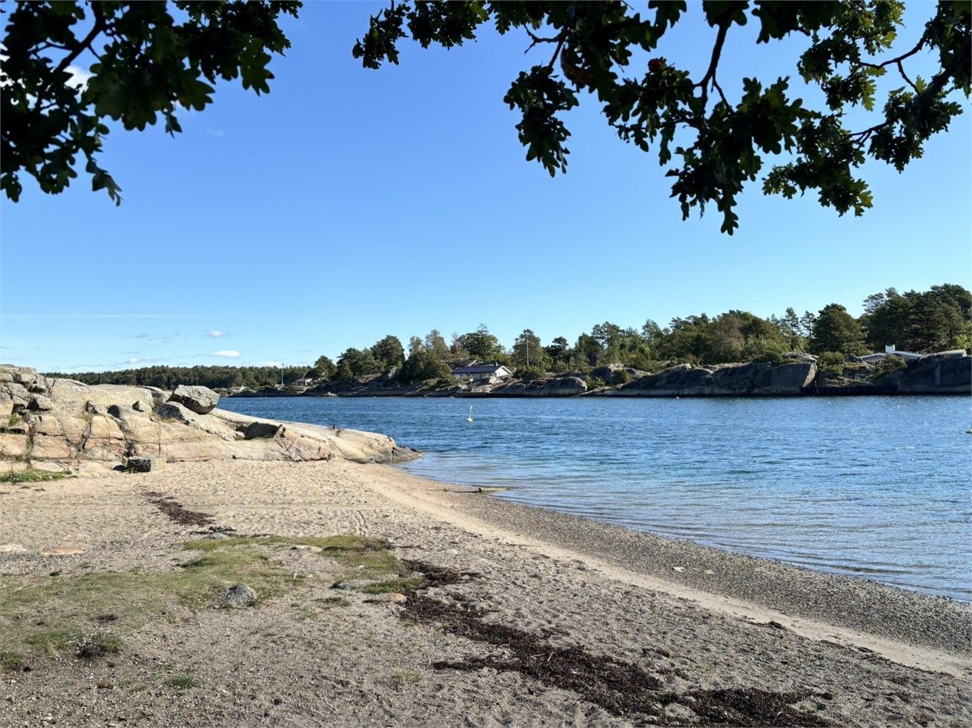 En lett tilgjengelig sti gjennom skogen fører deg til Ormelet og den barnevennlige stranden, Regnbuen