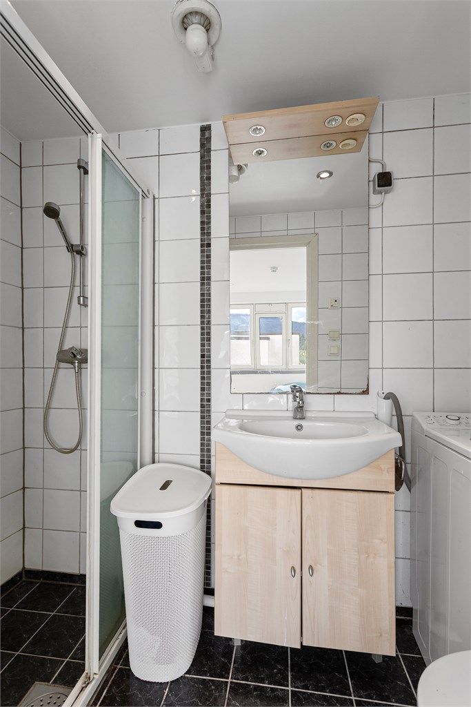 Flislagt bad med downlights i tak.