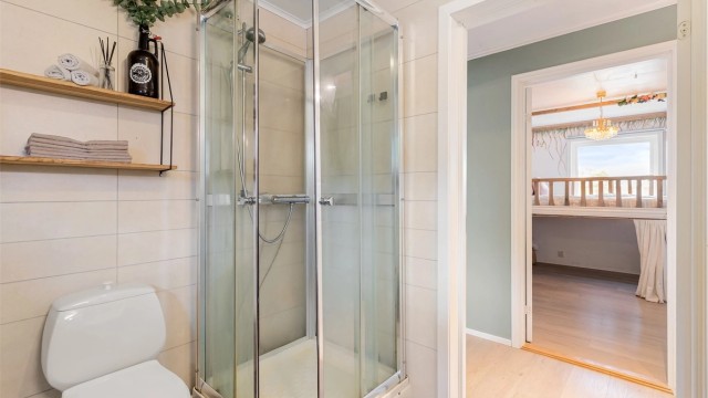 Badet har våtromsplater på veggene og flislagt gulv.