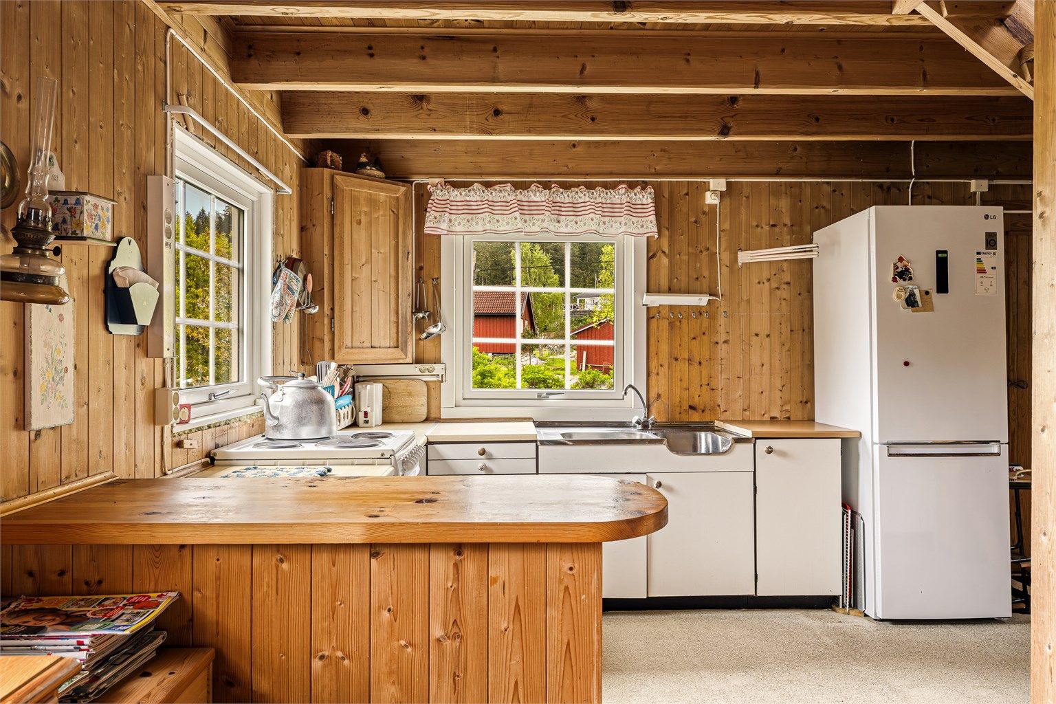 LANDLIG: Enkel kjøkkeninnredning med en benk som skaper skille mot stua.