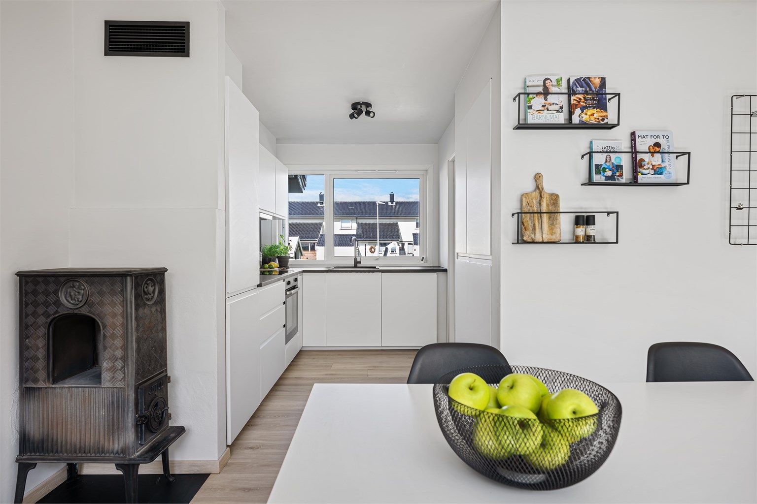 Kjøkkeninnredningen fra IKEA ( 2024),  i tidløs hvit og sort benkeplate. 
