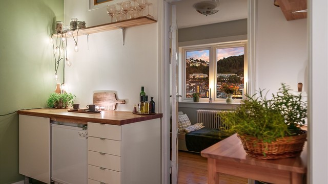 Kjøkken med benkeplate i treverk og siktlinje mot soverommet.