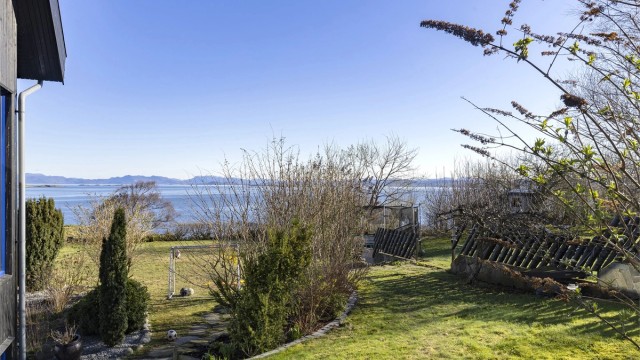 Fra hagen har man en åpen og vidstrakt utsikt over sjøen.