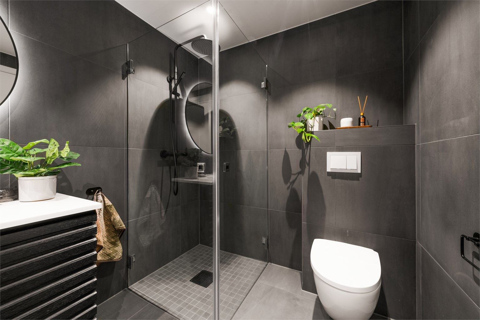 Dusjhjørnet er utstyrt med regnfallsdusj og praktiske, innfellbare glassdører.