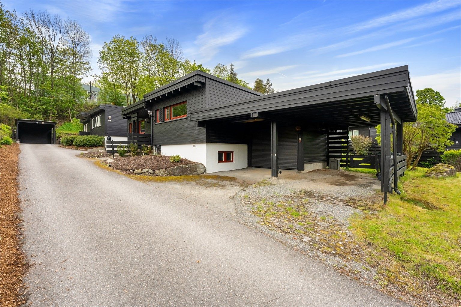 Boligen har garasje og carport samt mulighet til å sette biler på egen tomt