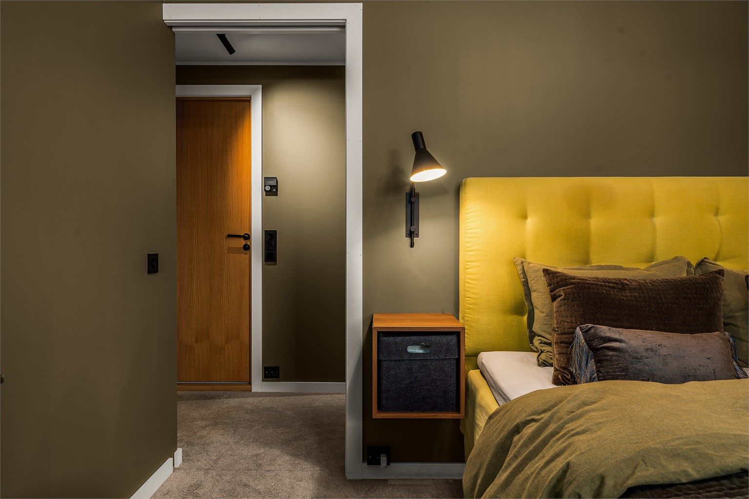 Lekre sorte detaljer i lys og brytere, som gir et moderne og rent uttrykk mot det gode fargevalget og eikedørene.