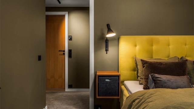 Lekre sorte detaljer i lys og brytere, som gir et moderne og rent uttrykk mot det gode fargevalget og eikedørene.