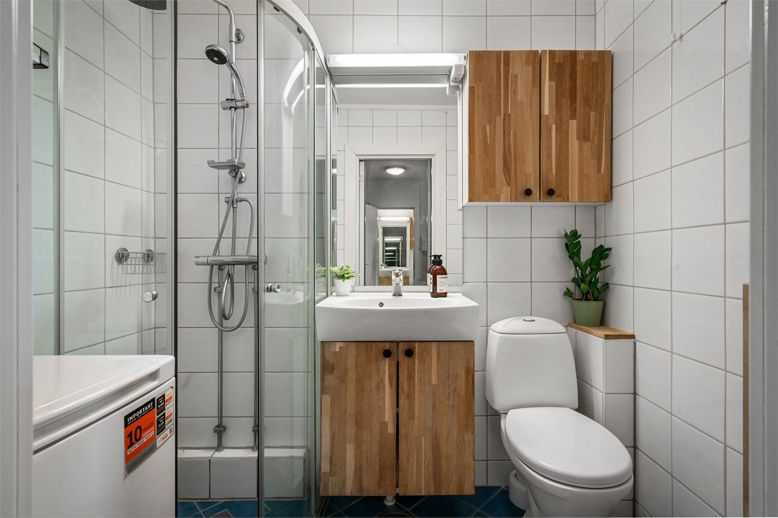 Flislagt baderom med gulvvarme og opplegg for vaskemaskin. Regnfalldusj og vanlig dusjhode