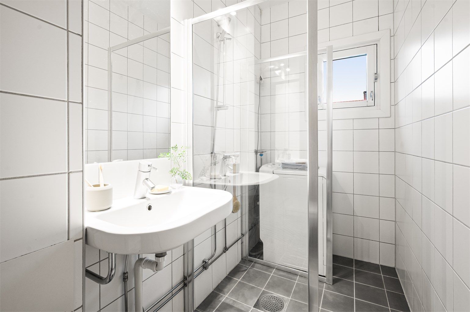 Himlingen er utført i malt flate. Badet er innredet med vegghengt servant med ettgreps armatur, speil og belysning over servant. 