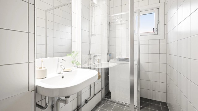 Himlingen er utført i malt flate. Badet er innredet med vegghengt servant med ettgreps armatur, speil og belysning over servant.