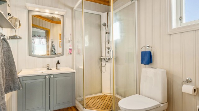 Natet teak i bunn av dusjkabinettet gir luksuriøs og eksklusiv stemning.