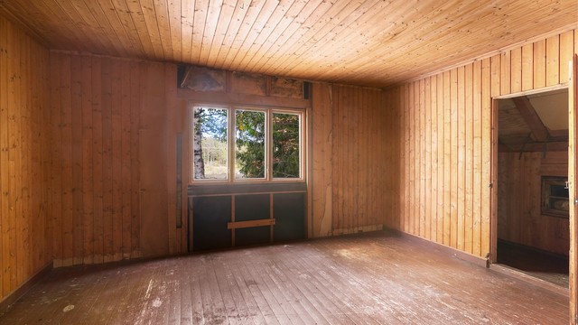 Soverom på loftet med furupanel, tregulv og dør til kott og bod.
