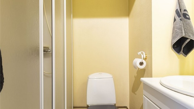 Bad med varmekabler i gulv. Dusjkabinett, wc og servantinnredning.