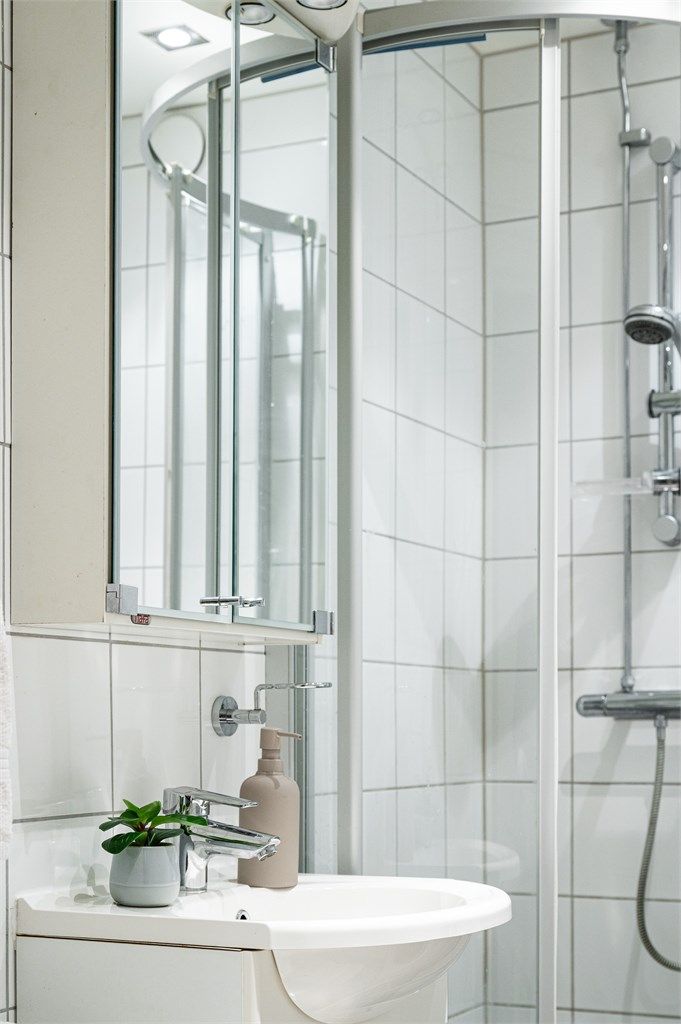 Flislagt bad med speilskap over servanten for praktisk oppbevaring.