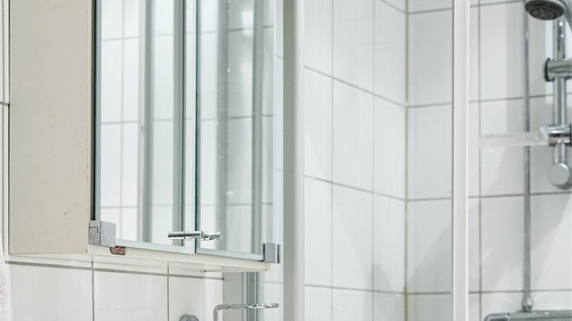 Flislagt bad med speilskap over servanten for praktisk oppbevaring.