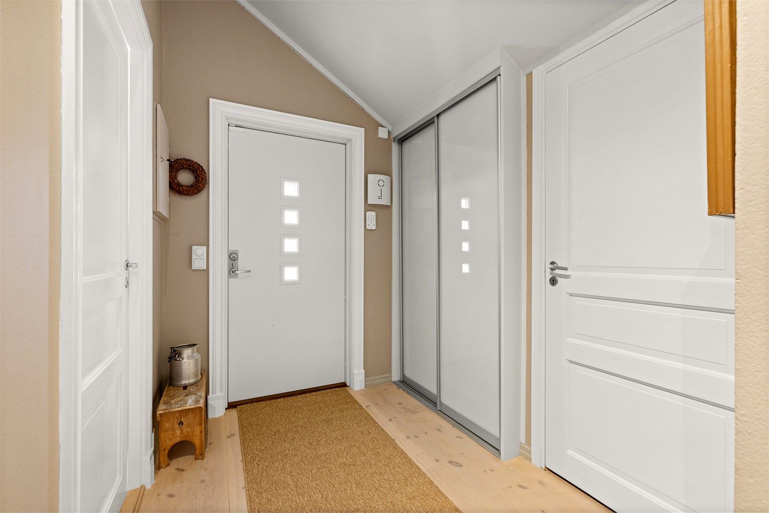 Praktisk skyvedørsgarderobe i entréen gir god plass til oppbevaring av yttertøy. Ytterdøren er fra 2015.