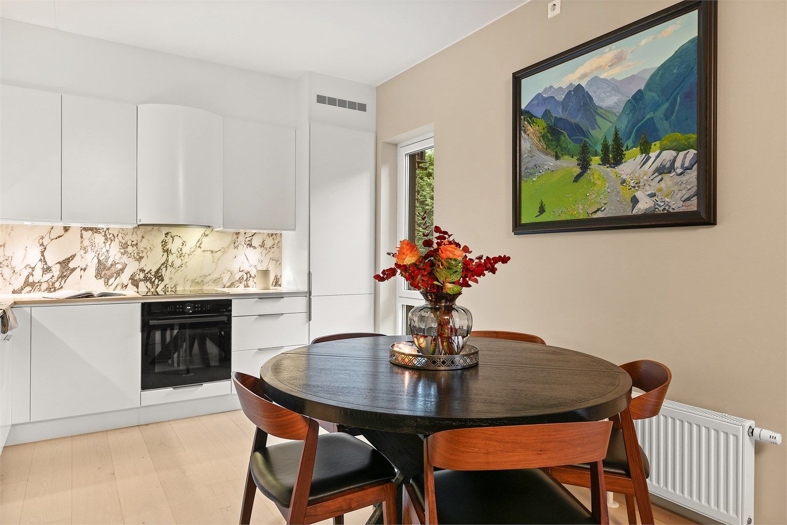 Kjøkken fra byggeår med glatte fronter og benkeplate i laminat.